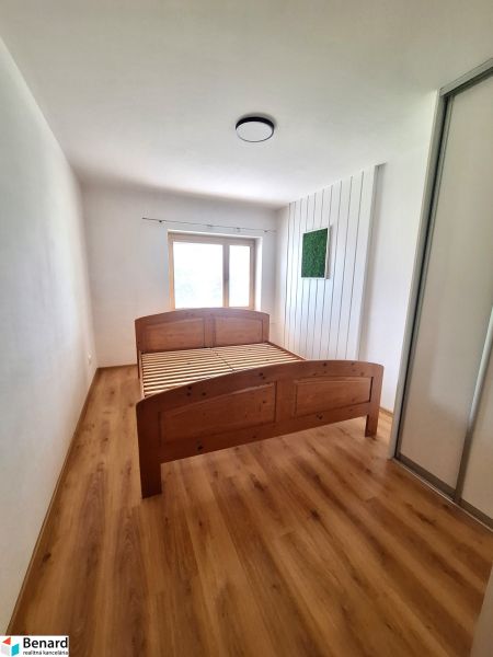 Hálószoba fa ággyal és beépített szekrénnyel egy kétszobás lakásban.