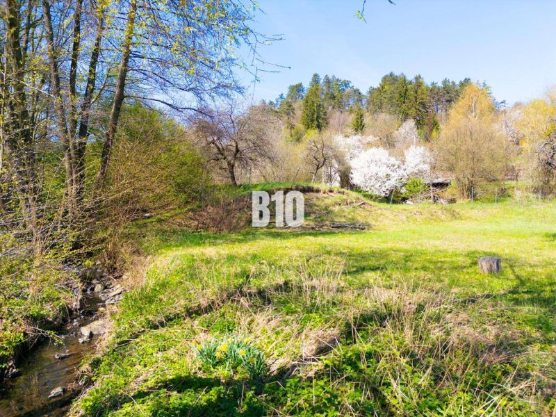 Zöldterület és patak lakóövezetben az Obrancov mieru utcában, Banská Štiavnica.
