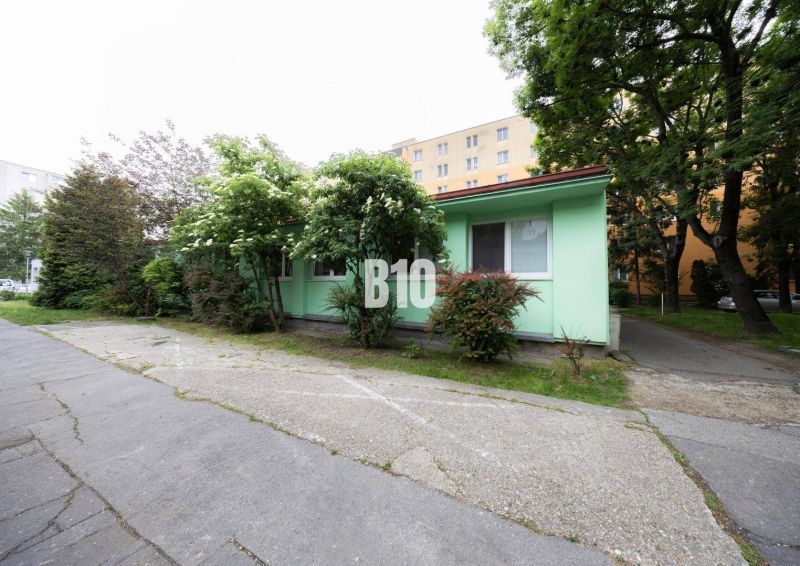 Egyszintes épület színes homlokzattal, fákkal körülvéve Pozsonyban - Ružinov, Ostredky.