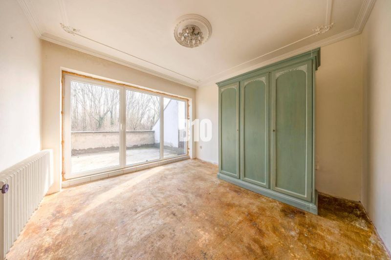 Egy családi ház szobájának belső tere nagy zöld szekrénnyel és üvegezett ajtókkal.