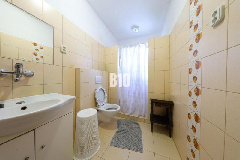 Fürdőszoba családi házban csempével és WC-vel.