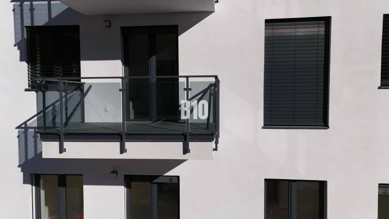 Erkély üvegezett korláttal és zsalugáterekkel egy kétszobás lakás épületén Alsókubinban.