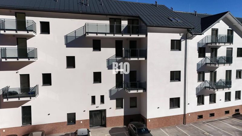 A Dolný Kubín-i lakóház homlokzata parkolóval és erkélyekkel, ideális egy kétszobás lakáshoz.