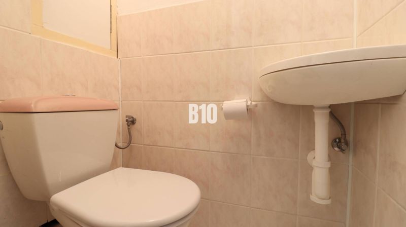 WC és mosdó a fürdőszobában egy 3 szobás lakásban, járólappal.