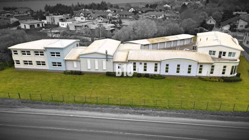 Gyártóhelyiségek Košťany nad Turcom-ban, kiterjedt zöld területtel az ipari övezetben.