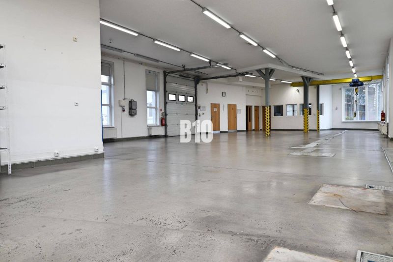 Világos gyártóterület betonpadlóval és magas mennyezettel.
