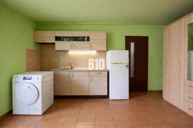 Konyha családi házban fa dekorációjú bútorokkal, zöld falakkal és csempével.