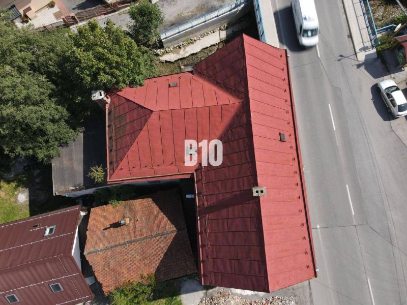 Egy épület teteje Bélán és egy út autókkal madártávlatból.