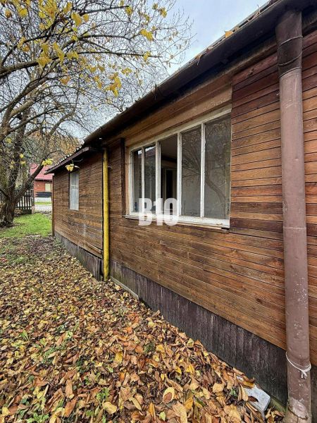 Családi ház Kotešovában régebbi fa homlokzattal, őszi levelekkel és fákkal körülvéve.