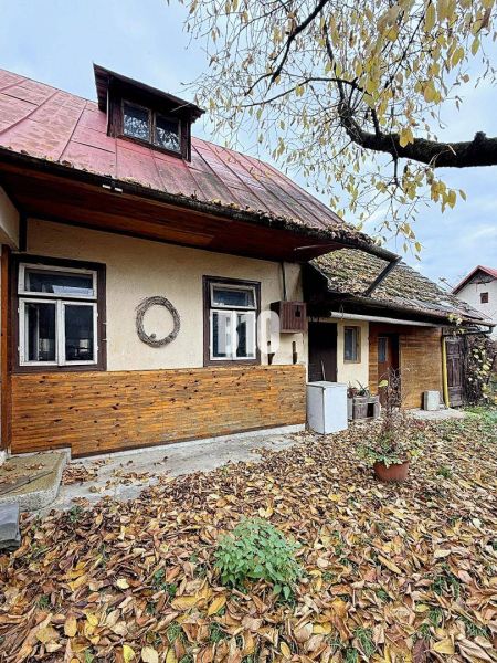 Kotešovai családi ház régi fa burkolattal és lehulló levelekkel a kertben.