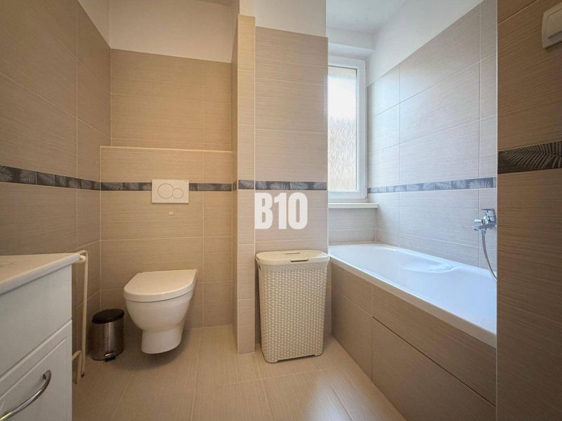 Fürdőszoba a nyaraló apartmanban káddal, WC-vel és modern burkolatokkal.