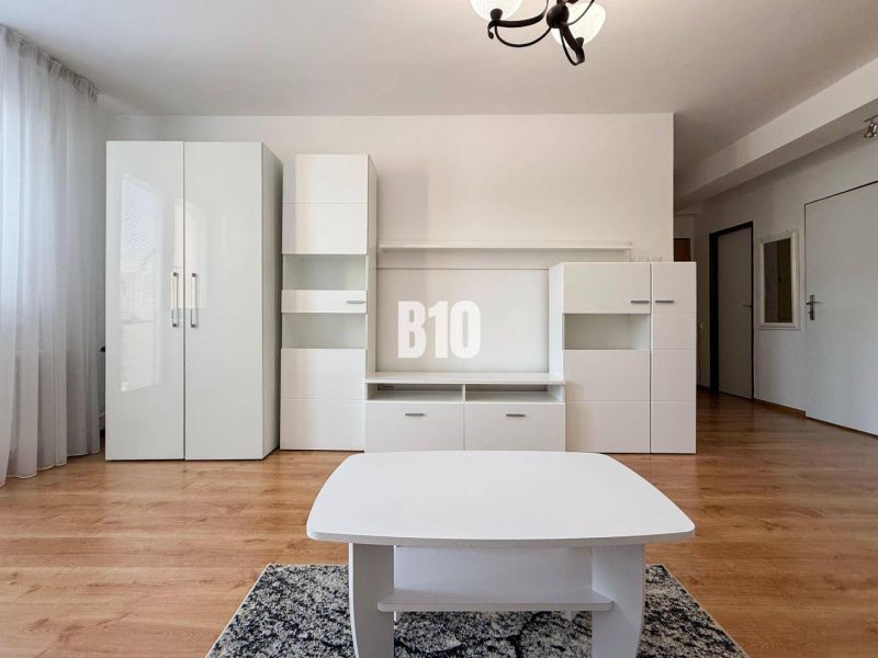 A fehér bútorokkal és fa dekorációjú padlóval rendelkező nyaraló apartman belső tere.