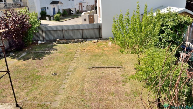 Kert a családi ház mögött, gyep és fák a Nabr. J. M. Hurbana utcában, Michalovce városában.