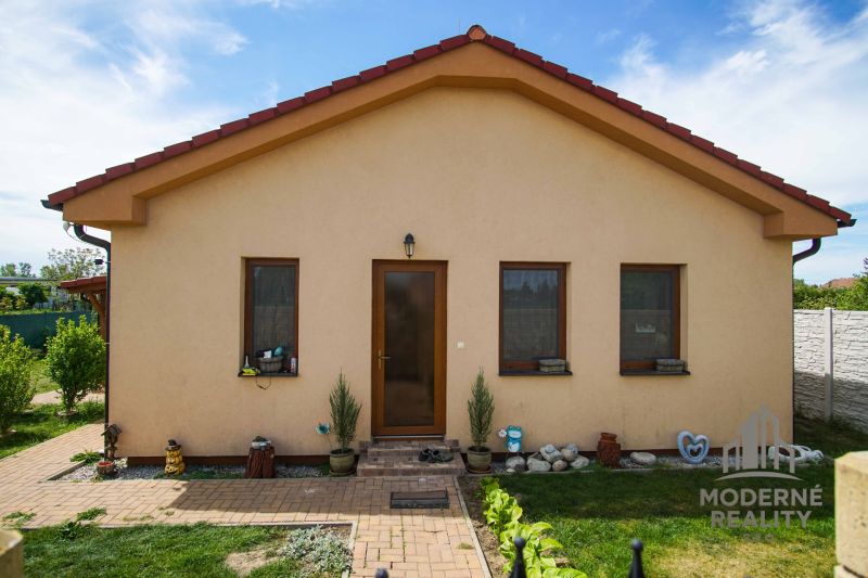 Családi ház Andócon három ablakkal, udvarral és virágágyással.