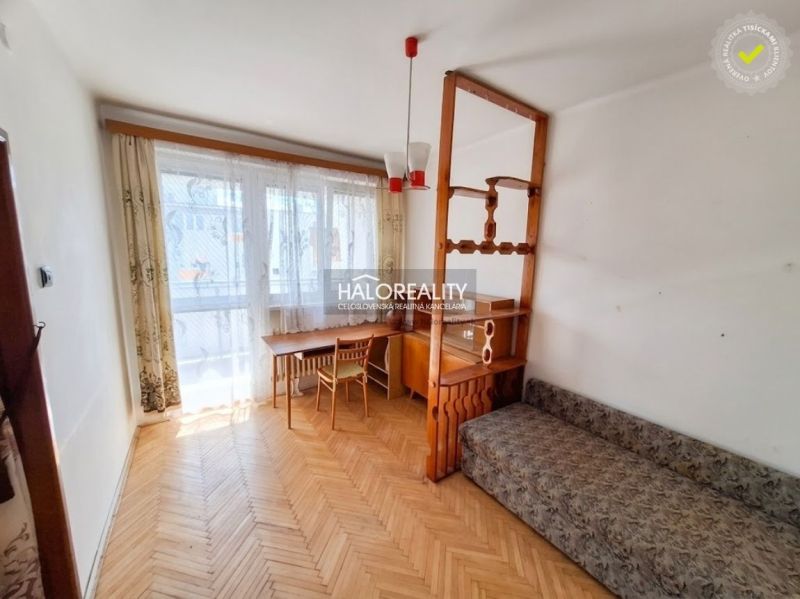 Nappali egy háromszobás lakásban fa dekoros padlóval és erkéllyel.