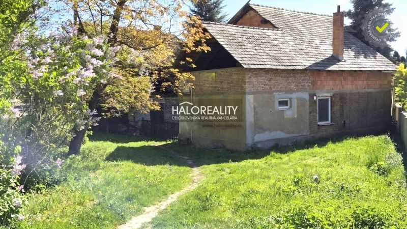 Családi ház Poltáron, zöld kerttel és virágzó fákkal körülvéve.
