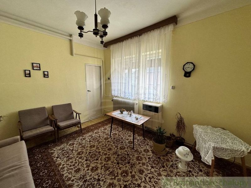 Nappali egy családi házban szőnyeggel és függönyökkel. A retro bútorok kiegészítik a hangulatos légkört.