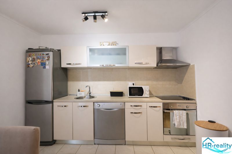 Konyhapult a nyaraló apartmanban rozsdamentes készülékekkel és mikrohullámú sütővel.