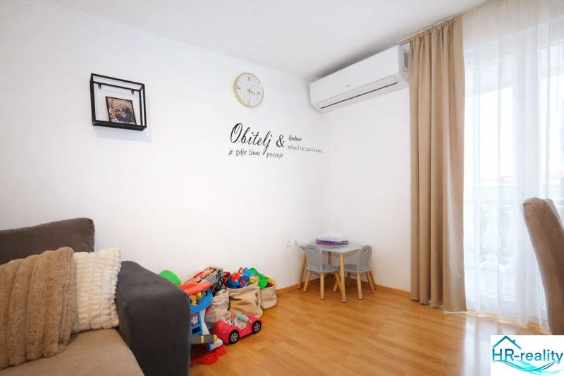 Nyaraló apartman belső tér játékszerekkel, kanapéval és fa dekorációjú padlóval.