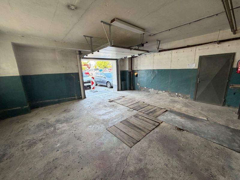A nyitott ajtajú garázs, beton padló. Autó nélkül.