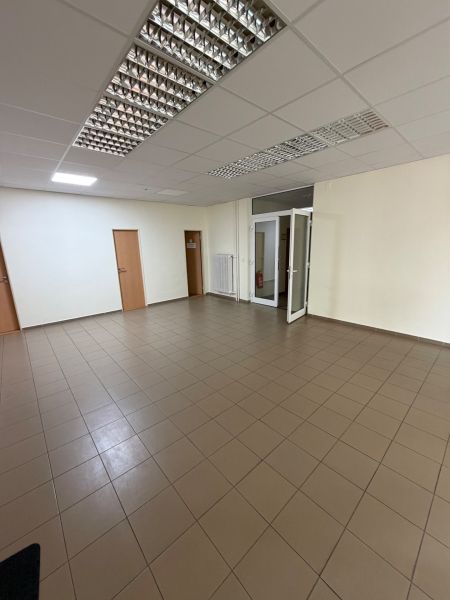 Üres irodák csempézett padlóval és fehér falakkal.