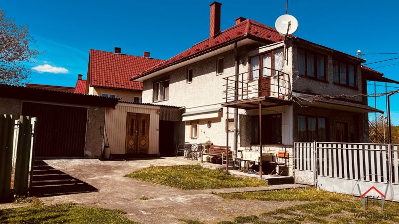 Családi ház Újkelcsén, Újkelcse udvarral, garázzsal és erkéllyel a kék ég alatt.