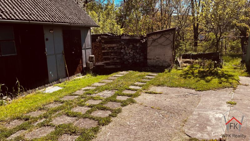 Udvar egy családi ház mellett Újkelcsén, garázzsal és fatároló kandallóval.