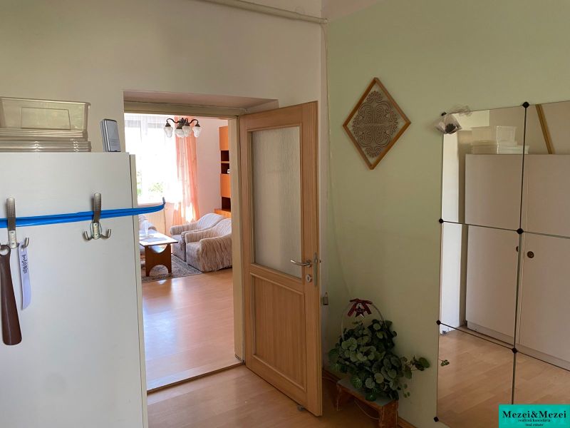 2 szobás lakás belső tere fa hatású padlóval, látható nappali.