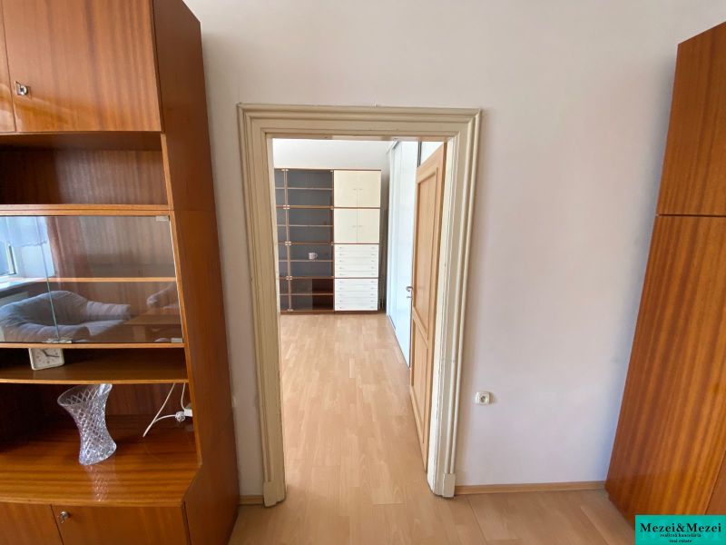 2 szobás lakás belső tere fa dekoros padlóval és fa bútorokkal.