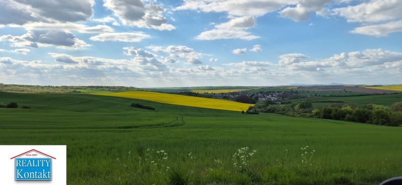A falu lenyűgöző kilátást nyújt a zöld tájra a kék éggel és felhőkkel.