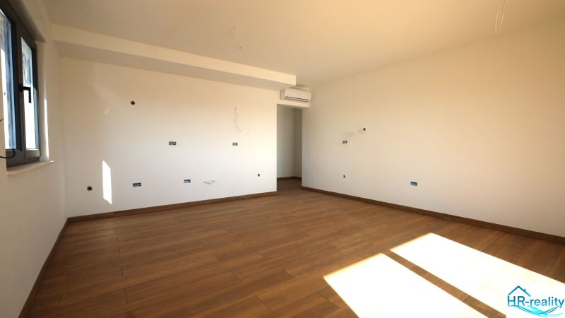 Világos szoba fa dekorációjú padlóval egy üdülő apartmanban.