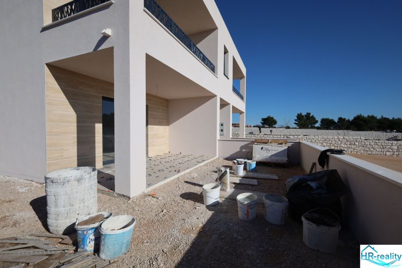 Rekreációs apartman építés alatt Vodicében, terasszal és építőanyaggal körülvéve.