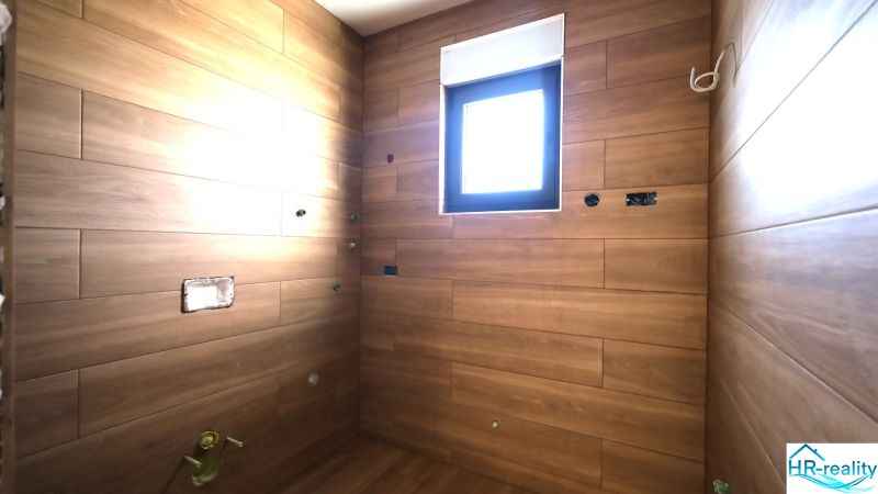 Rekreációs apartman fa dekorációs burkolatokkal és kis ablakkal.