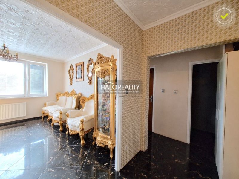 Luxusos belső tér egy egyszobás lakásban, pompás berendezéssel, arany kiegészítőkkel és dekoratív mennyezettel.