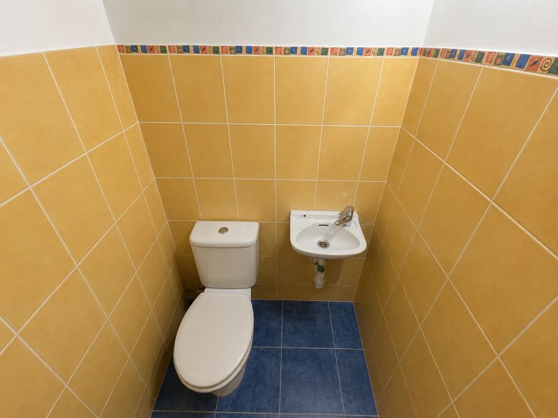 WC mosdóval a fürdőszobában, színes csempékkel egy kétszobás lakásban.