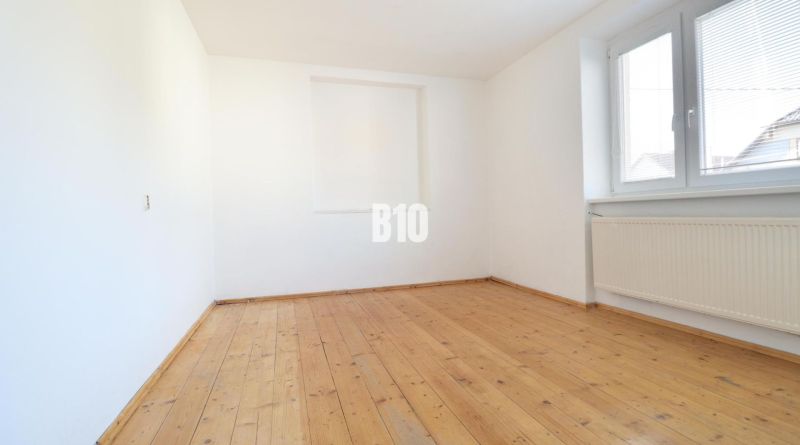 Üres szoba fa mintázatú padlóval egy családi házban.