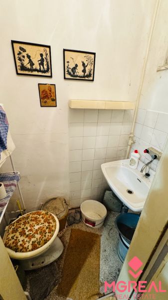 Kis fürdőszoba mosdóval és dekorációkkal egy háromszobás lakásban.