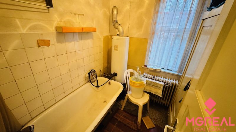 Fürdőszoba káddal és bojlerrel egy háromszobás lakásban.
