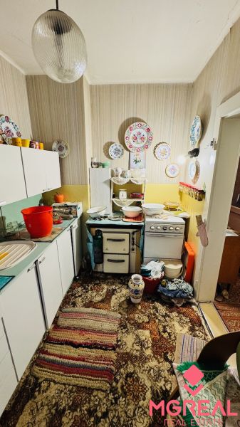 Konyha vintage dekorációval egy háromszobás lakásban és színes mintás szőnyeggel.
