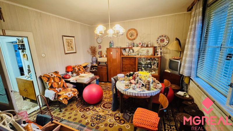 Egy háromszobás lakás szobája, amely tele van vintage bútorokkal és dekorációkkal, fa dekoros padlóval.