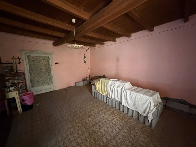 Szoba egy családi házban antik világítással és gerendás mennyezettel.
