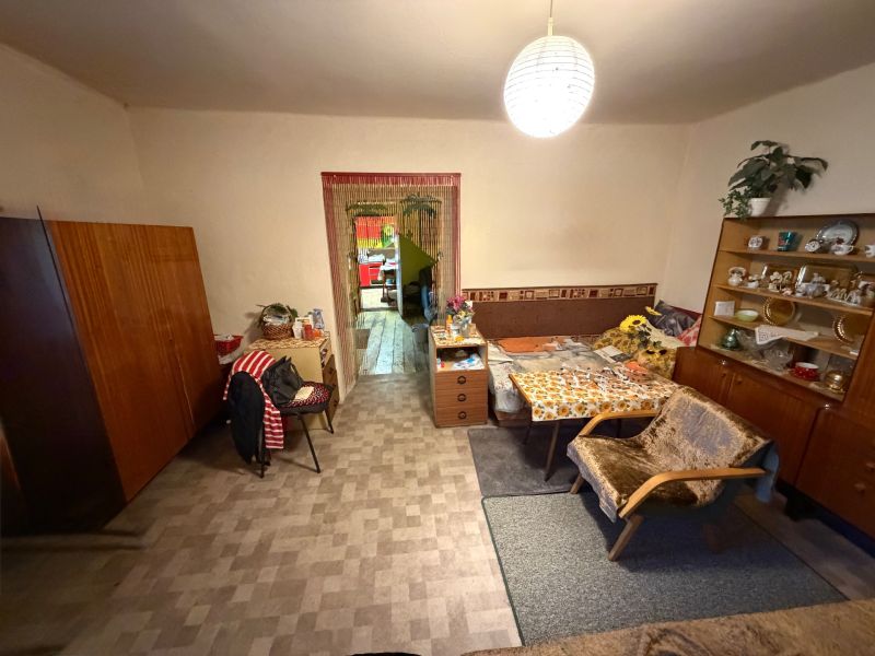 Nappali egy családi házban antik bútorokkal és karosszékekkel, fa dekoros padlóval.