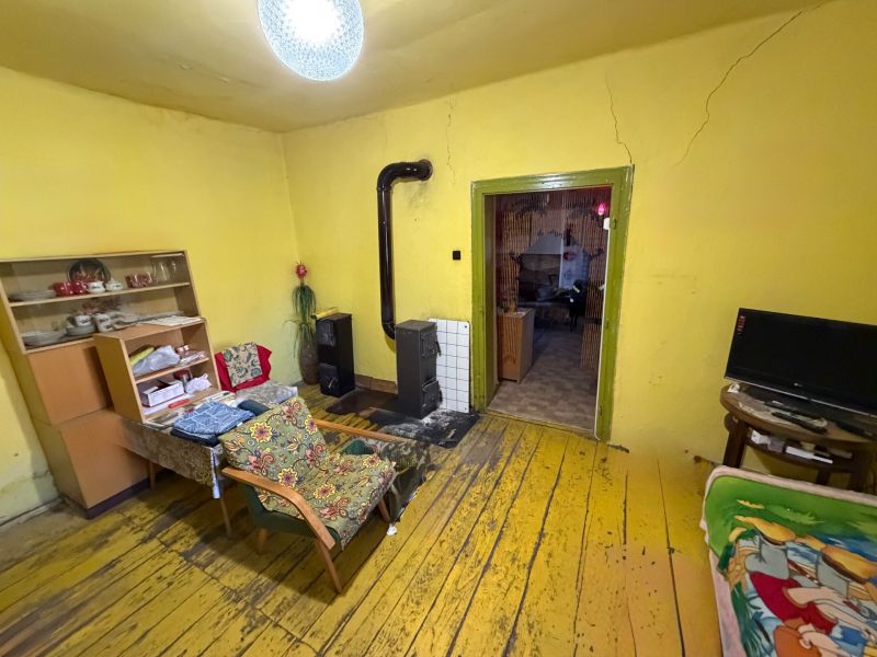 Nappali családi házban kandallóval, sárga falakkal és fa mintázatú padlóval.