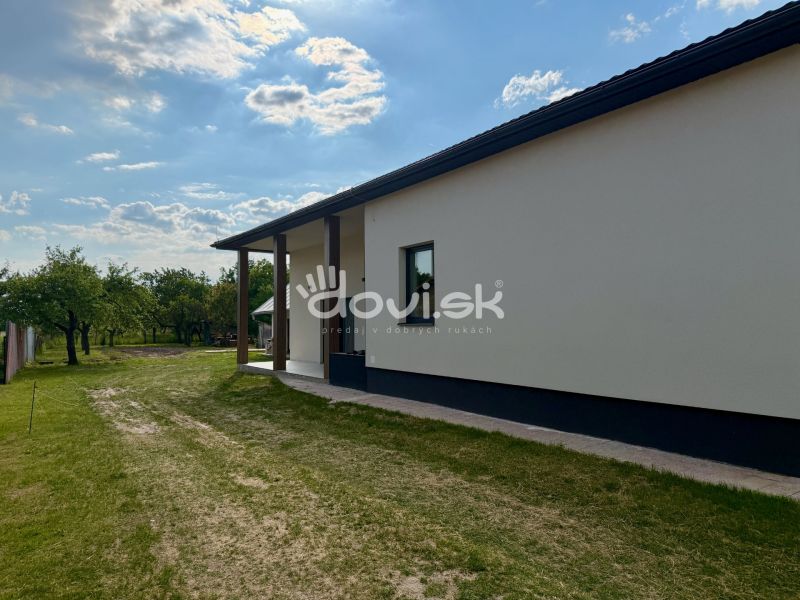 Egy családi ház külseje Zemplínska Širokában, gyep és fák veszik körül.