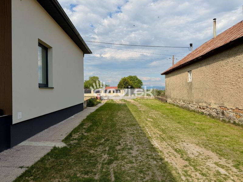 Családi ház Zemplínska Širokában, épületek közötti gyepes területtel és rendezett járdával.