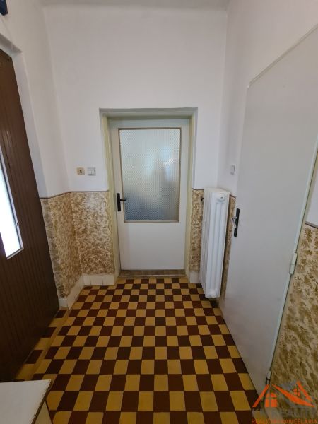 Sakktáblaszerű burkolat egy családi ház belső terében fehér falakkal.