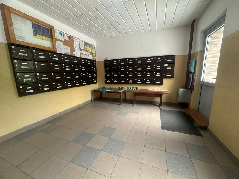 A bejárat belső tere postaládákkal és faliújságokkal a kétszobás lakás területén.