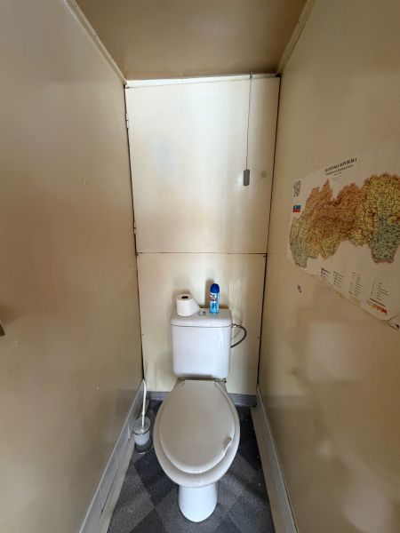 Szoros WC térképpel a falon egy háromszobás lakásban.