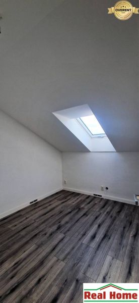 Tetőtéri szoba fa dekoros padlóval és tetőablakkal egy családi házban.