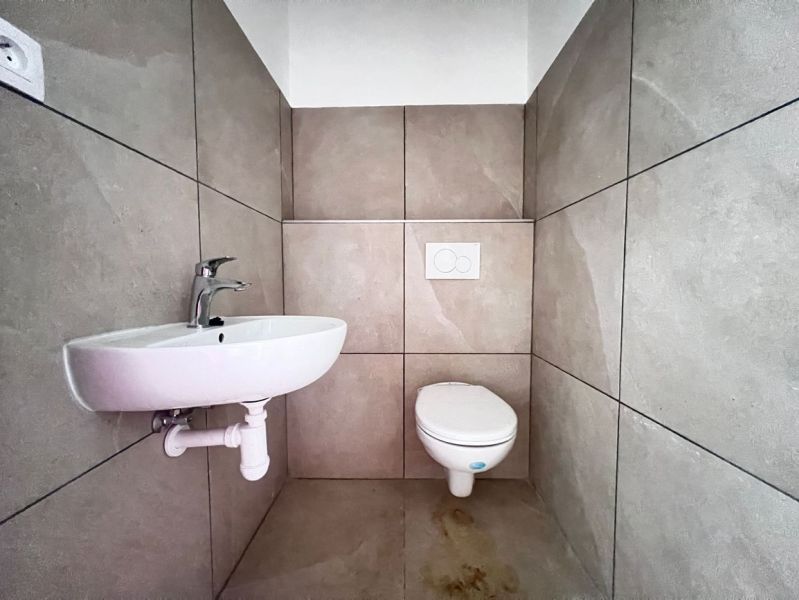 WC mosdókagylóval, semleges csempék, üzlethelyiségek.